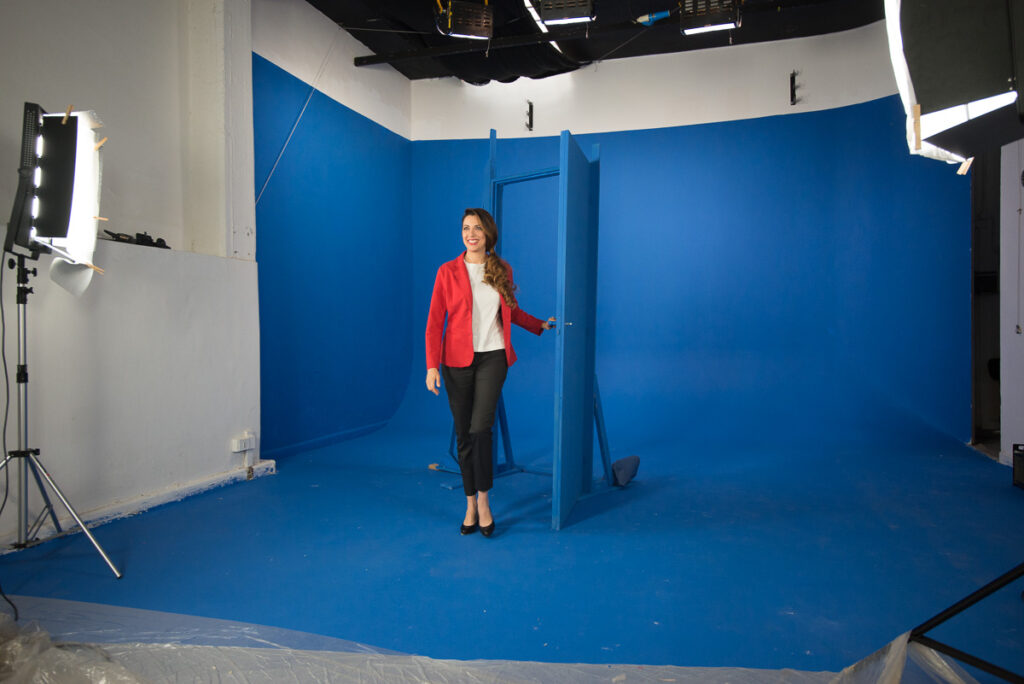 Instudio.org: Model in Red Jacket Shot on Studio C Blue Screen Walking Through Blue Door
